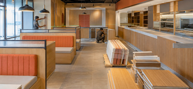 Wall panelling and booth seating being fitted on site during a flatpack restaurant installation